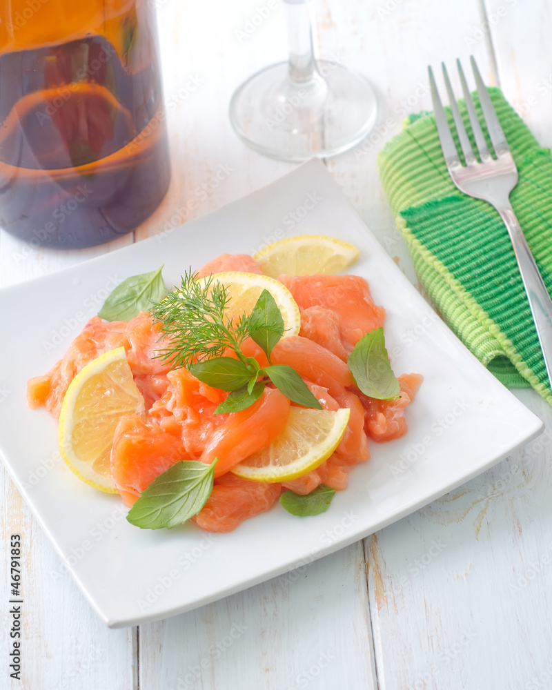 fresh salmon with lemon on the white plate fresh salmon with lemon on the white plate