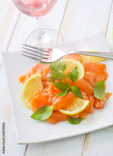 fresh salmon with lemon on the white plate