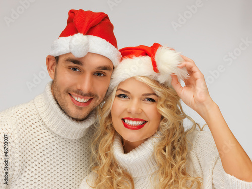 family couple in sweaters and santa s hats