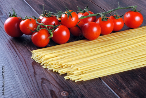 spaghetti and tomatoes on a wooden table