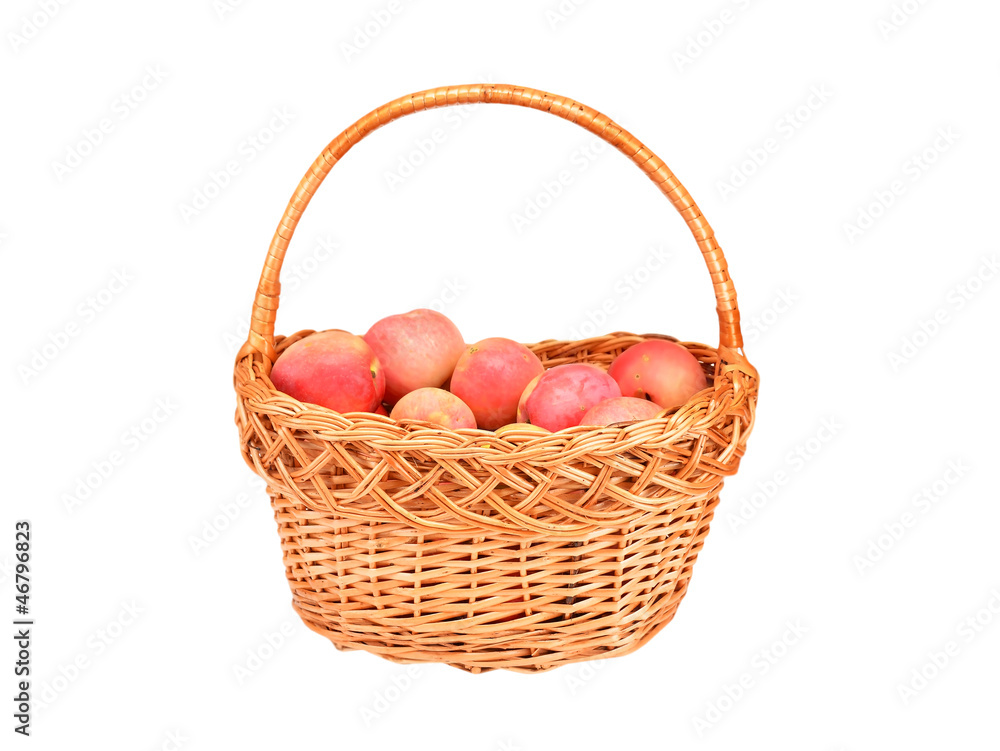 Red apple in a wattled basket, isolated on white background