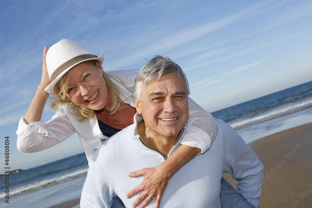 Portrait of cheerful senior couple having fun at the beach