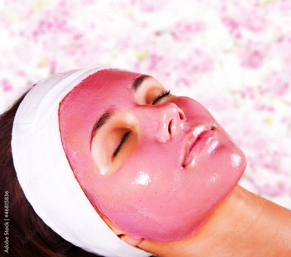 Fototapeta premium Young beautiful woman with moistening fruit facial mask at beaut