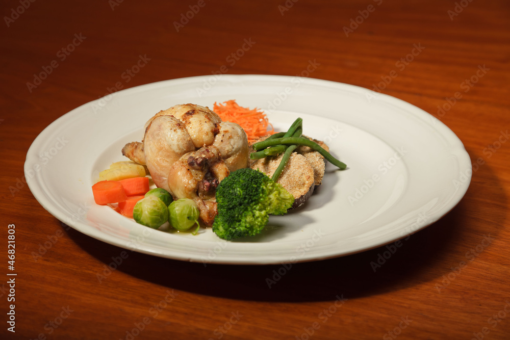 Dinner of vegetables and chicken on a plate and wooden table. Dinner of vegetables and chicken on a plate and wooden table.