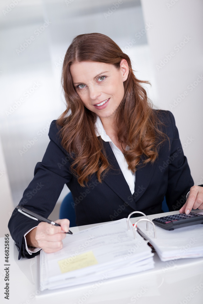 Smiling accountant sitting at her desk working