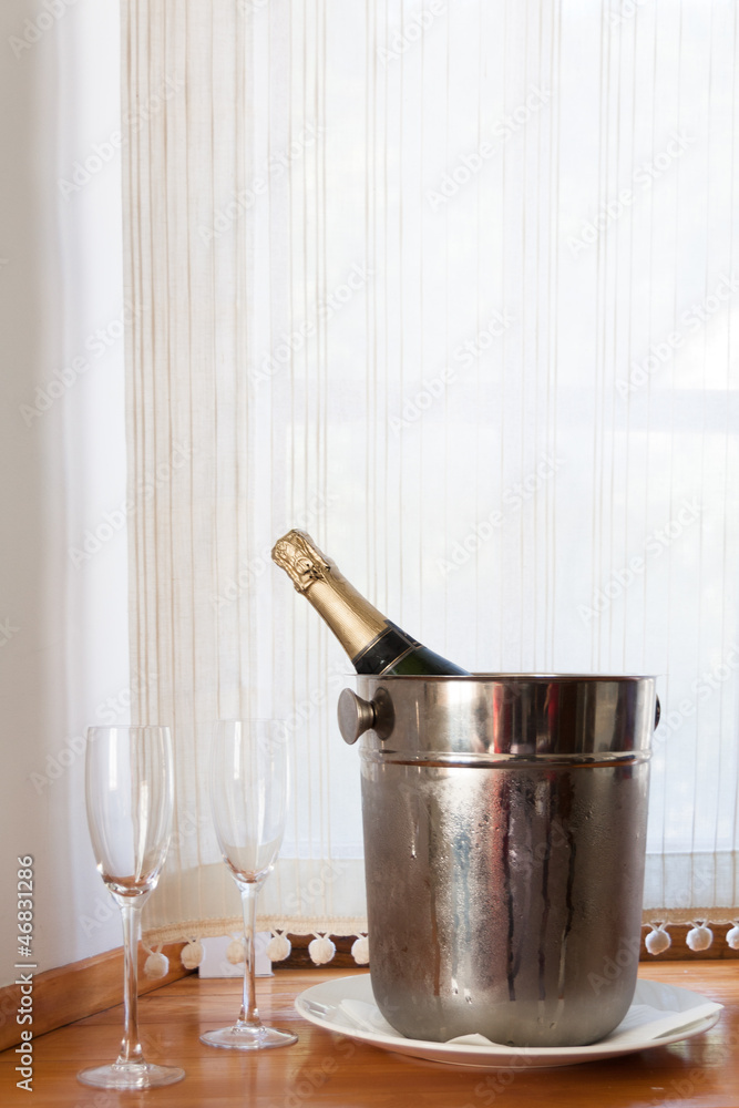 Champagne bottle in bucket with ice and two glasses of champagne Champagne bottle in bucket with ice and two glasses of champagne