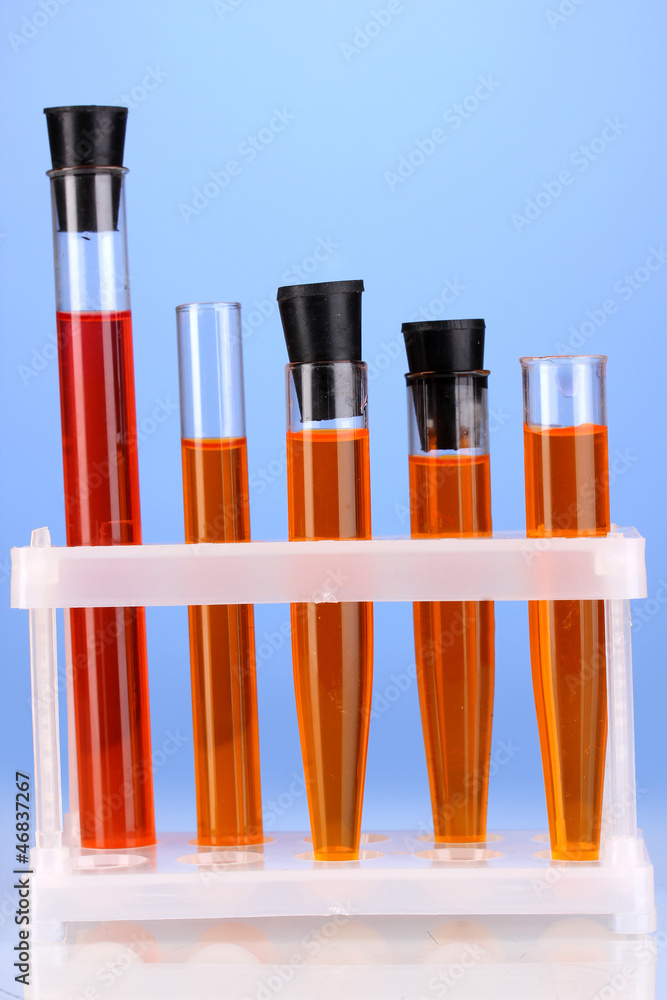 Test-tubes with a colorful solution on blue background close-up Test-tubes with a colorful solution on blue background close-up