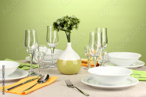 Table setting in green and yellow tones on color  background © Africa Studio