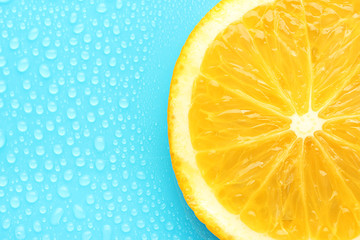 Slice of lime with drop on blue background