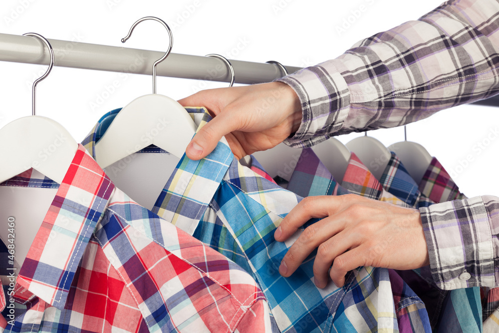 Man in checked shirt choosing another checked shirt Man in checked shirt choosing another checked shirt