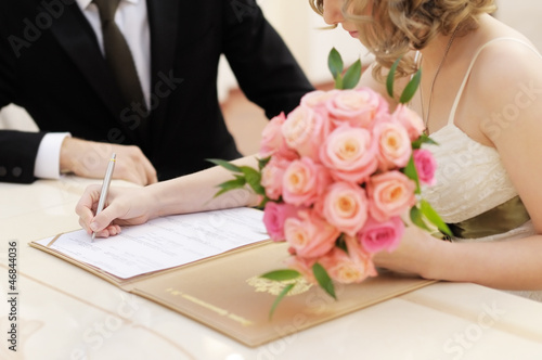 Foto Bride signing marriage license or wedding contract