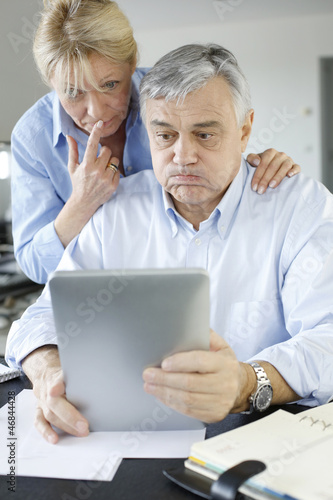 Senior couple trying to figure out tax declaration © goodluz