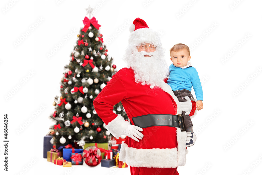 Santa Claus and child posing in front of a decorated christmas t Santa Claus and child posing in front of a decorated christmas t