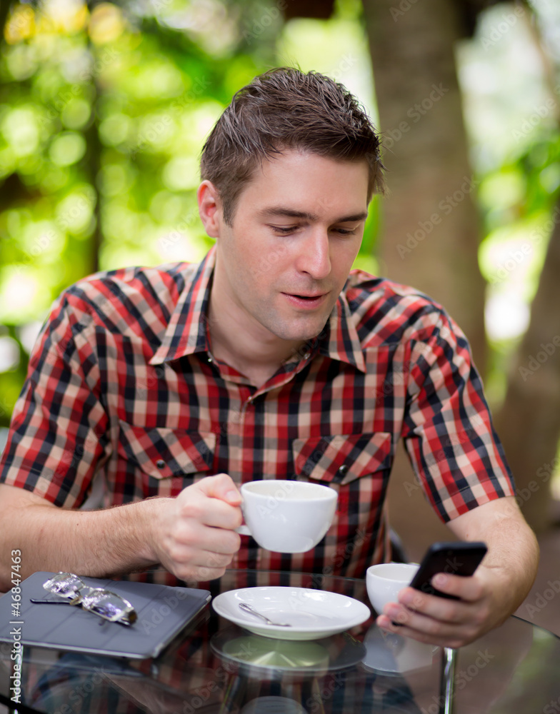 Business man sitting at table in cafe using mobile phone Business man sitting at table in cafe using mobile phone