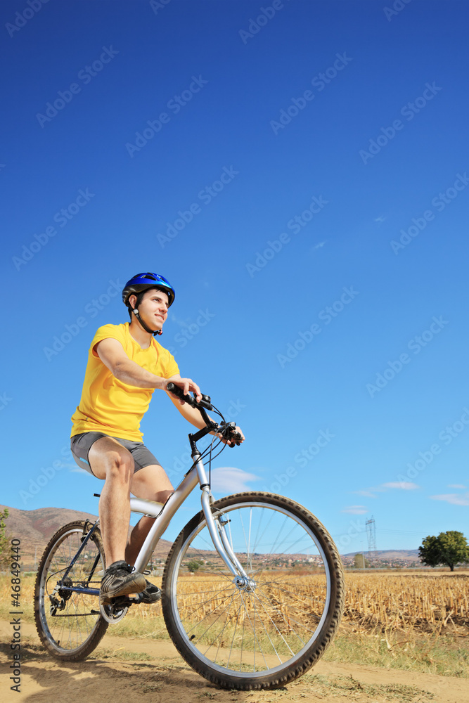 Young male riding a bike on a sunny day