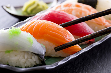 Gordijnen Sushi bar Verse sushi rolletjes op schaal  © HLPhoto