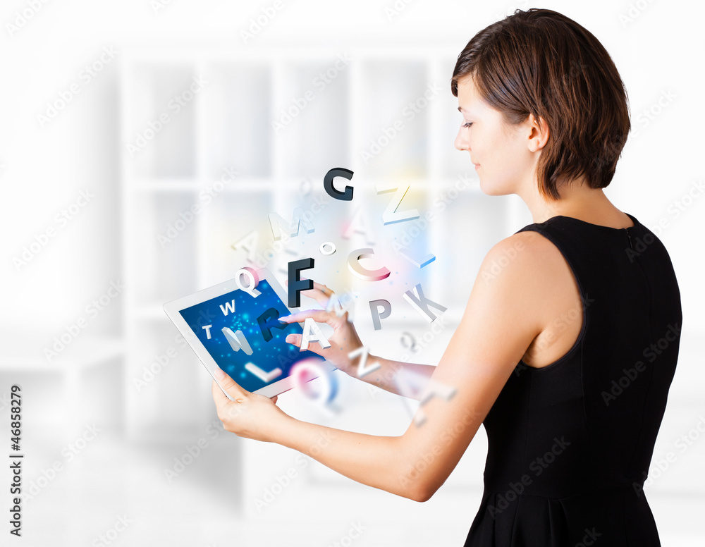 Young woman looking at modern tablet with alphabet Young woman looking at modern tablet with alphabet