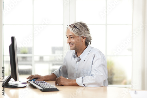 A man sits in front of the PC and works