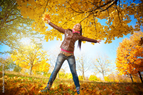 girl on a background of sky and autumn leafs
