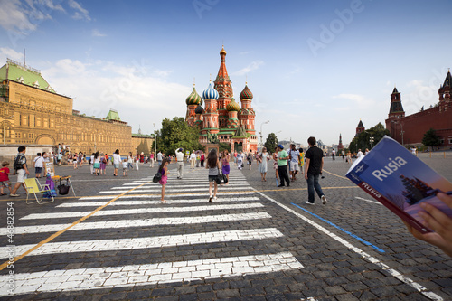 a tourist looking at his Guide in front of St. Basil's Cathedral