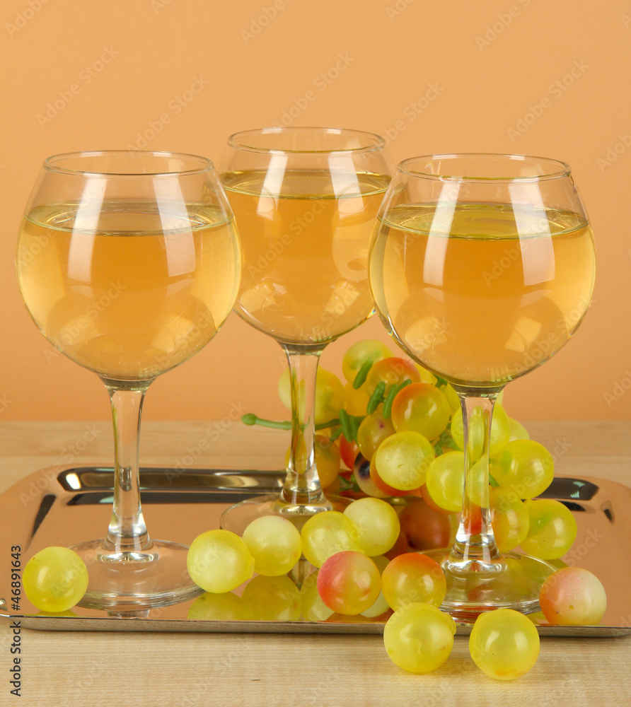 White wine in glass on salver on beige background White wine in glass on salver on beige background