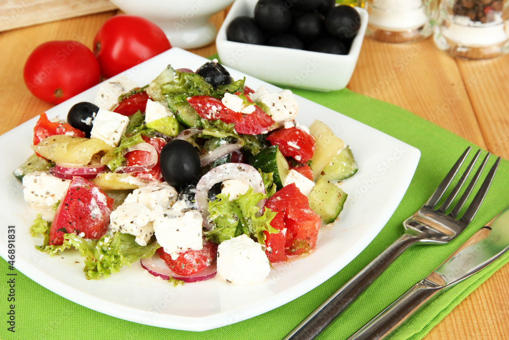 Fresh greek salad on plate on wooden table close-up Fresh greek salad on plate on wooden table close-up