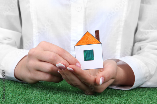 concept: woman hands with paper house, close up