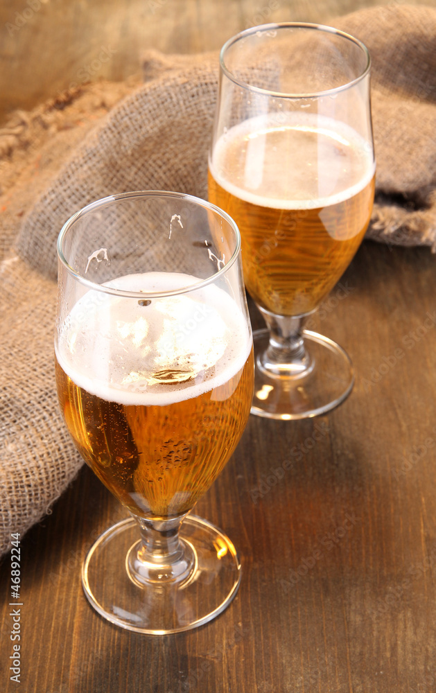 Glasses of beer on wooden table close-up Glasses of beer on wooden table close-up
