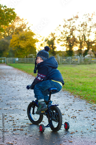 Fototapeta Naklejka Na Ścianę i Meble -  boy riding his bike through a countryside path