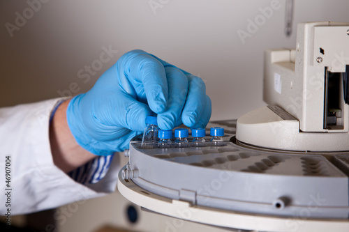 Scientist holds a chemical sample bottle photo