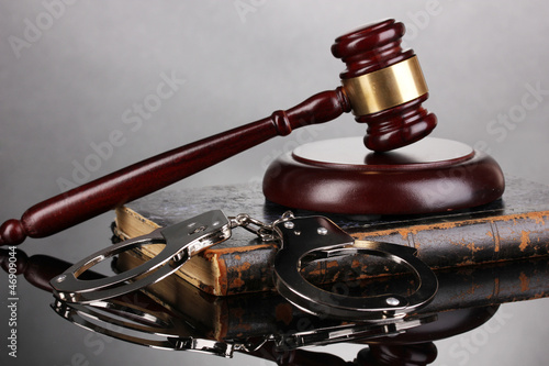 Gavel, handcuffs and.book on law on grey background