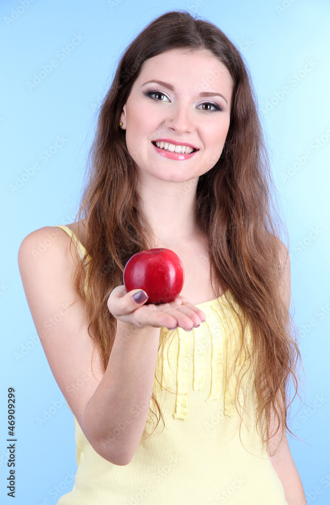 Beautiful woman with apple on blue background Beautiful woman with apple on blue background