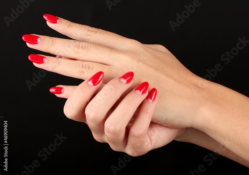Fotografie, Obraz Beautiful female hands with red nails isolated on black