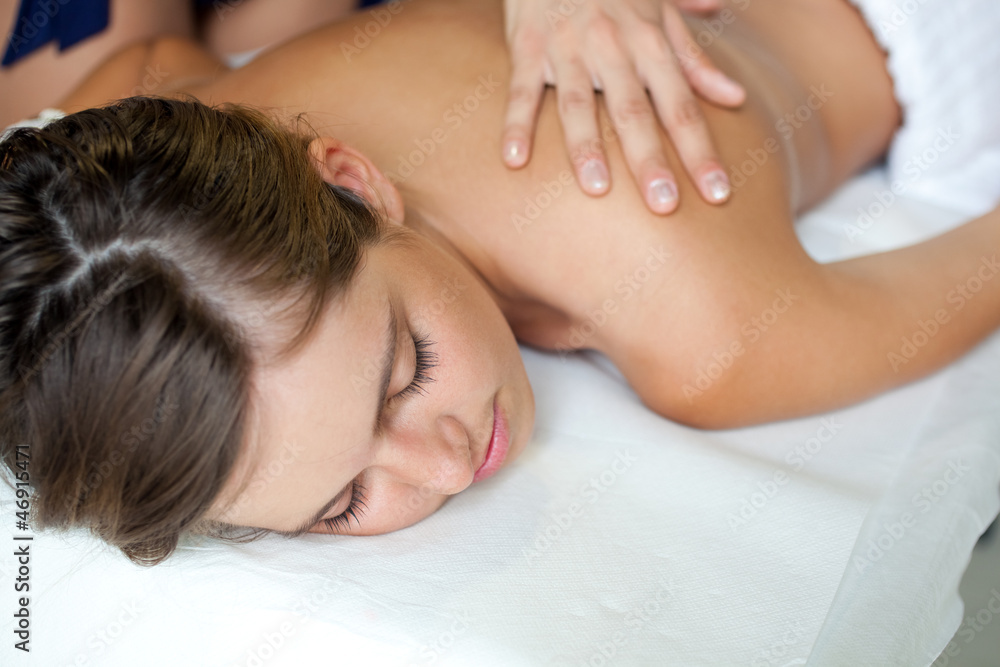 Relaxed woman receiving a massage in a spa Relaxed woman receiving a massage in a spa
