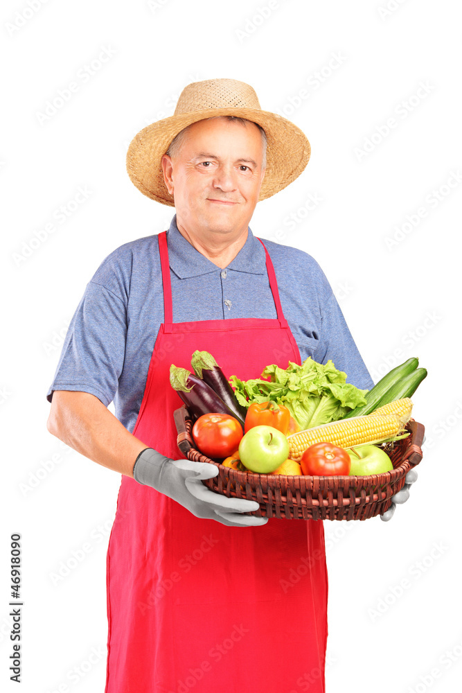 Mature farmer man holding a basket with fresh vegetables Mature farmer man holding a basket with fresh vegetables