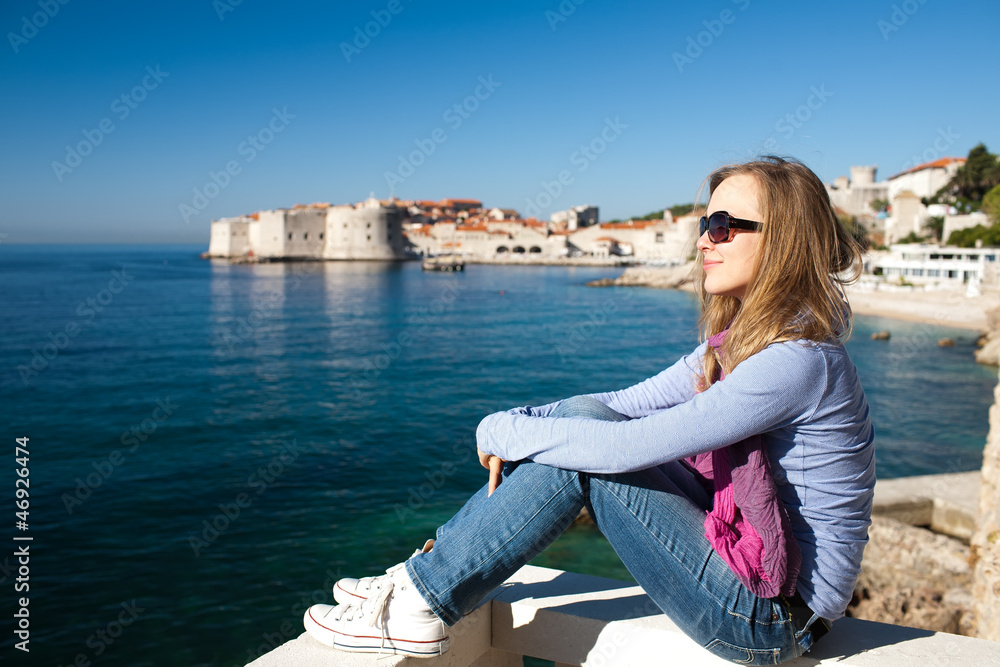 Woman sitting on pier on Adriatic sea, Europe