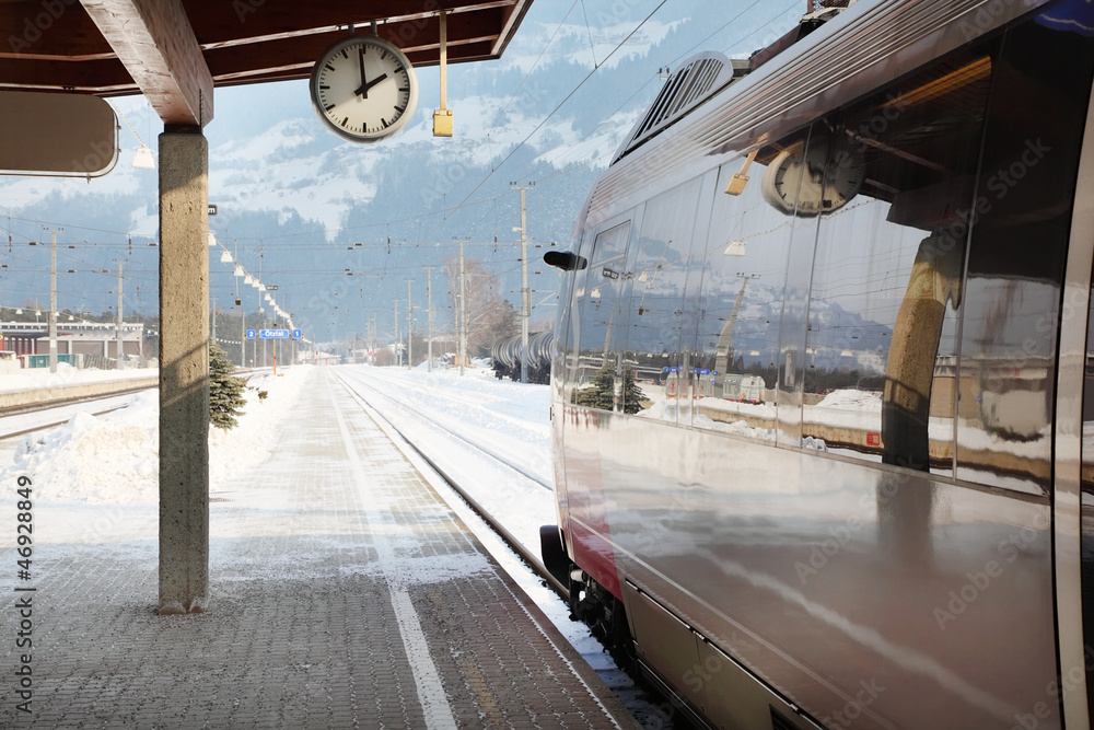 Naklejka premium Clock and train in railway station at winter