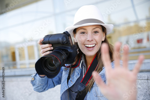 Cheerful photographer showing hand towards camera