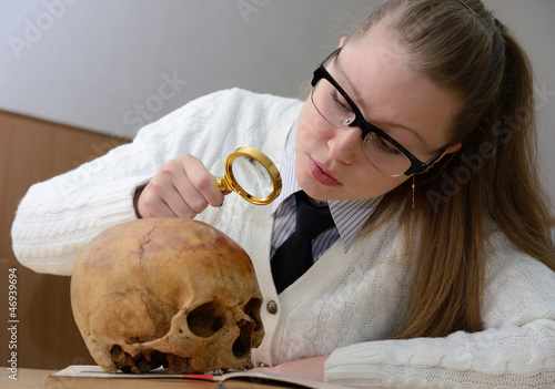 Фотография Woman examining a human skull