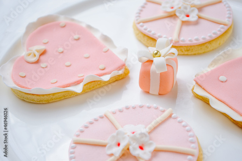 many pink cookies on a white plate