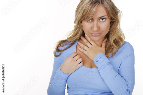 Junge Frau fasst sich an den Hals bei Halsschmerzen photo