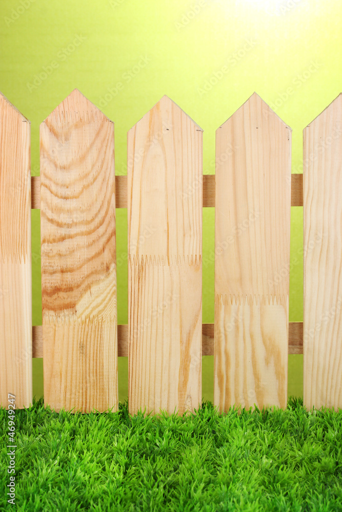 Fototapeta premium A wooden fence on a green background close-up