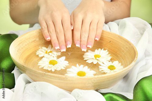 Fototapeta Naklejka Na Ścianę i Meble -  woman hands with wooden bowl of water with flowers,