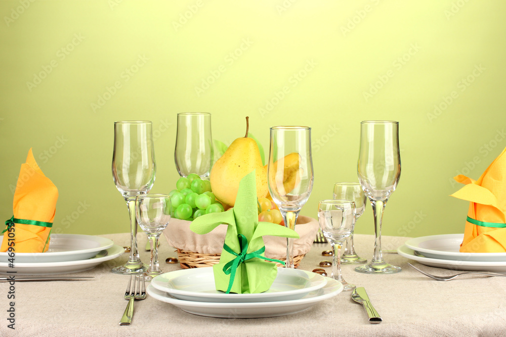 Table setting in green and yellow tones on color background Table setting in green and yellow tones on color background