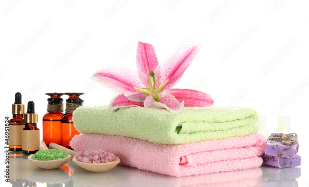 towels with lily, aroma oil, soap and sea salt isolated on towels with lily, aroma oil, soap and sea salt isolated on