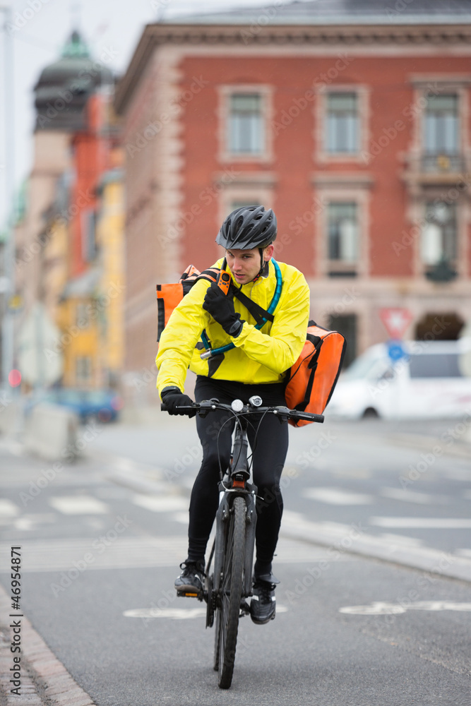 Cyclist With Courier Bag Using Walkie-Talkie Cyclist With Courier Bag Using Walkie-Talkie