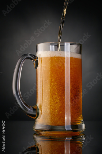 Mug of beer over dark background