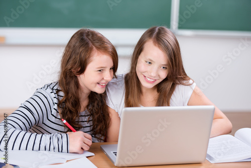 zwei schulkinder arbeiten mit laptop photo