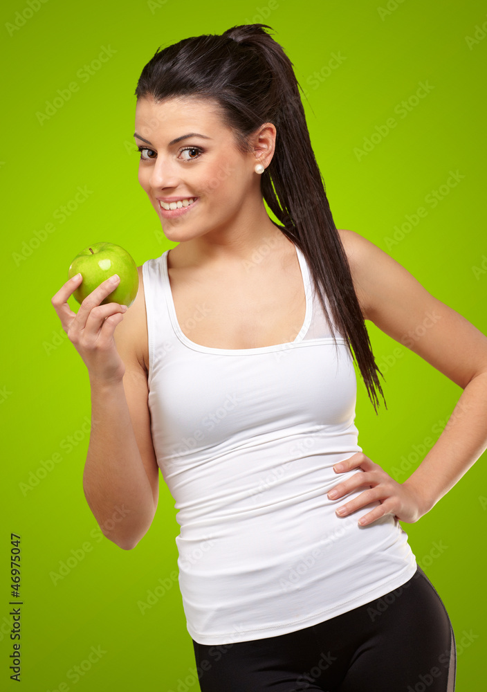 Young woman holding and eating an apple Young woman holding and eating an apple