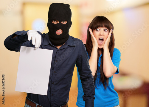 Tableau sur toile Burglar Man Holding Paper In Front Scared Woman